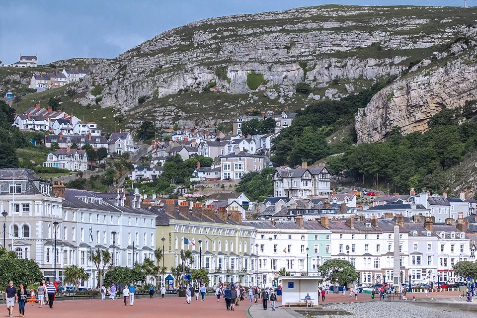 Scenic view of a coastal town with colorful buildings and a rocky hillside.